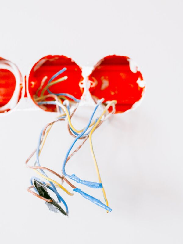 Bunte Kabel, die aus Löchern für Steckdosen ragen Bunte Kabel, die aus Löchern für Steckdosen ragen