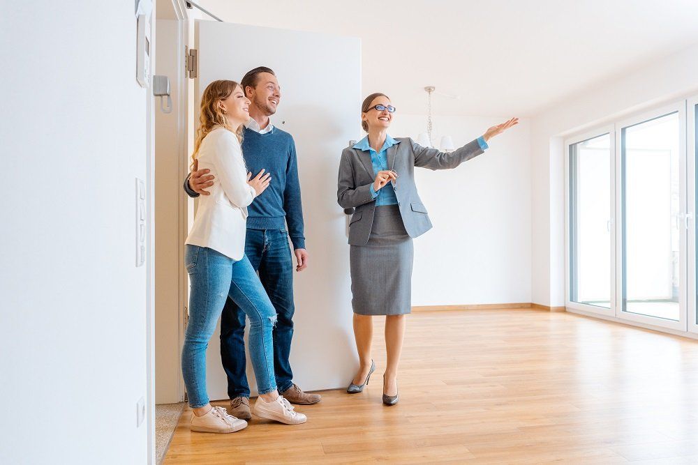 Maklerin zeigt Pärchen eine Wohnung