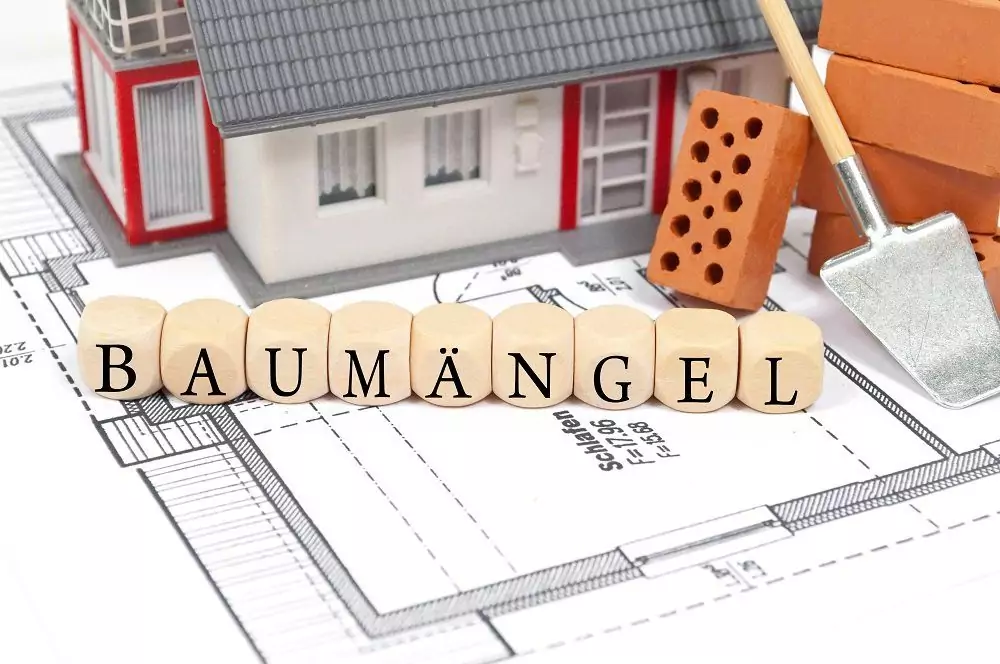 Bauplan mit Ziegelstein und Haus mit Baumängel