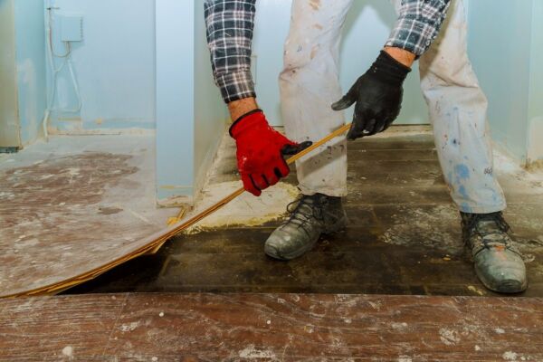 Handwerker entfernt Parkett, um Boden zu sanieren Handwerker entfernt Parkett, um Boden zu sanieren