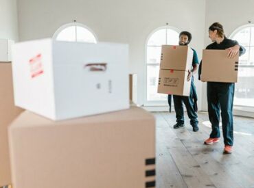 Möbelpacker räumen bei Auszug Kartons aus der Wohnung