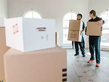 Möbelpacker räumen bei Auszug Kartons aus der Wohnung