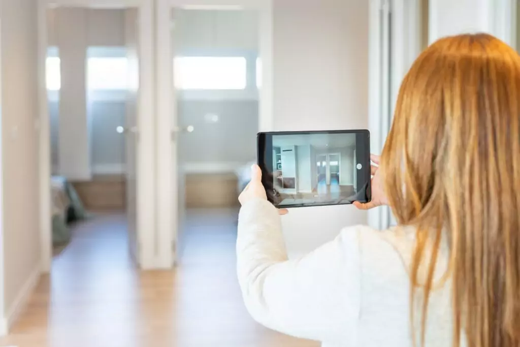 Frau macht mit Tablet Fotos von einer Wohnung