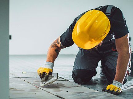 Handwerker saniert einen Boden.