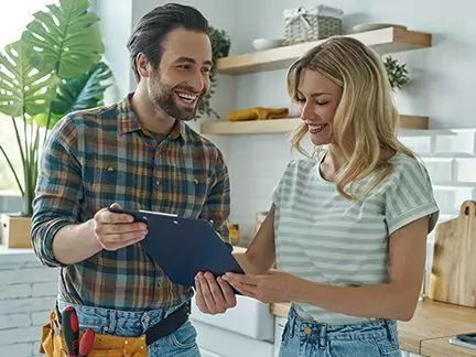 Auftraggeberin koordiniert einen Handwerker für eine Sanierung.