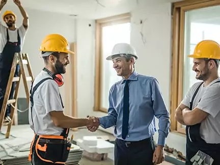 Auftraggeber und Handwerker geben sich die Hand bei der Bauüberwachung.