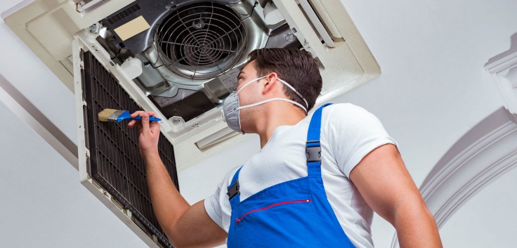 Handwerker reinigt einen Luftschaft während den Sanitärarbeiten bei einer Sanierung.